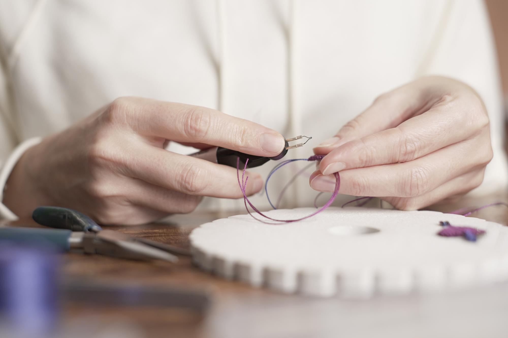 artisan at work embroidering detail